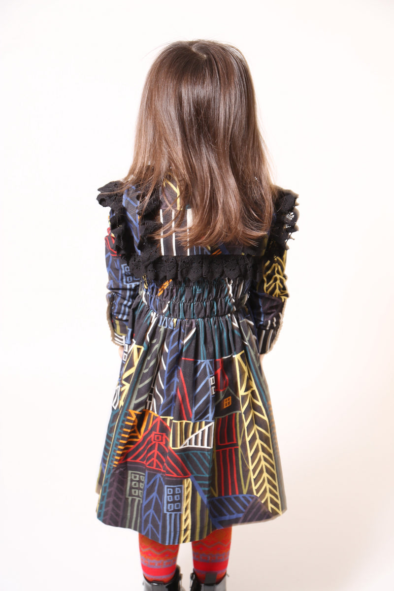 Girl wearing a flared long sleeve frock in this season's Normanz print on soft corduroy features black color smocking at the bodice, Multicolour, Tia Cibani.