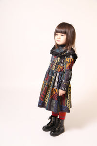 Girl wearing a flared long sleeve frock in this season's Normanz print on soft corduroy features black color smocking at the bodice, Multicolour, Tia Cibani.