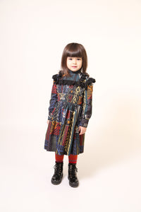 Girl wearing a flared long sleeve frock in this season's Normanz print on soft corduroy features black color smocking at the bodice, Multicolour, Tia Cibani.