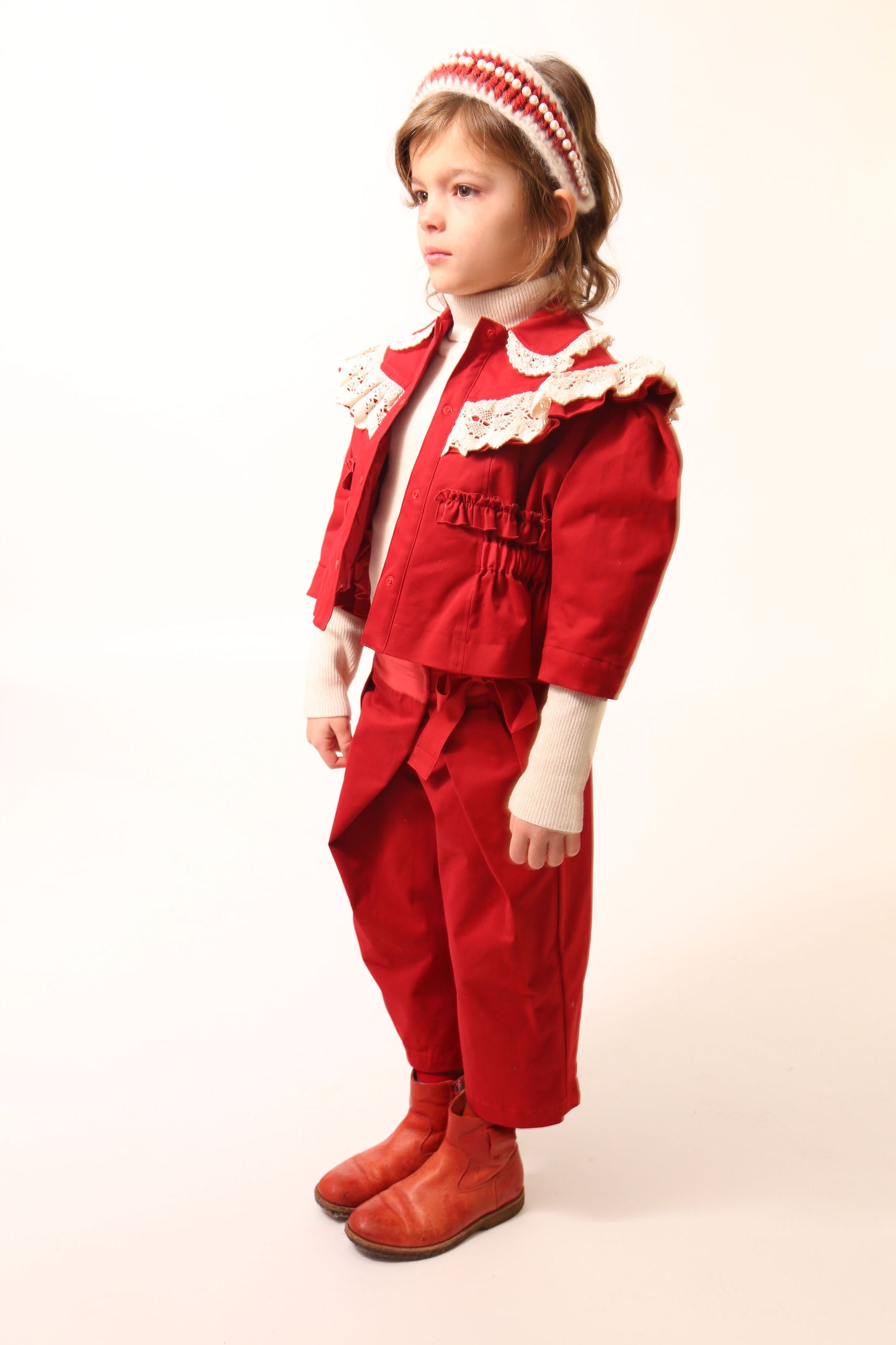 Girl wearing a charming volume topper jacket in soft Chamois Cotton Twill with contrasting lace embellishments, Red and White, Tia Cibani.