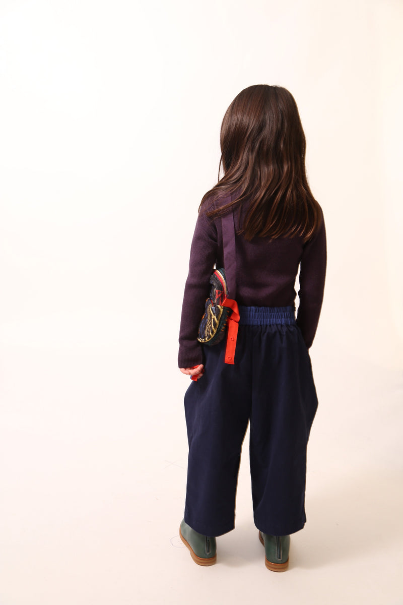 Deep pleated trousers designed for comfort and style, featuring an easy elastic waistband with ribbon tie detailing for a charming bow at the side waist. Crafted in comfortable Chamois Cotton Twill, unlined for lightweight feel, perfect for everyday wear. Complete with slant pockets at side seams. Pair with Gwenn Collared Topper for a complete look. Blue, Tia Cibani.