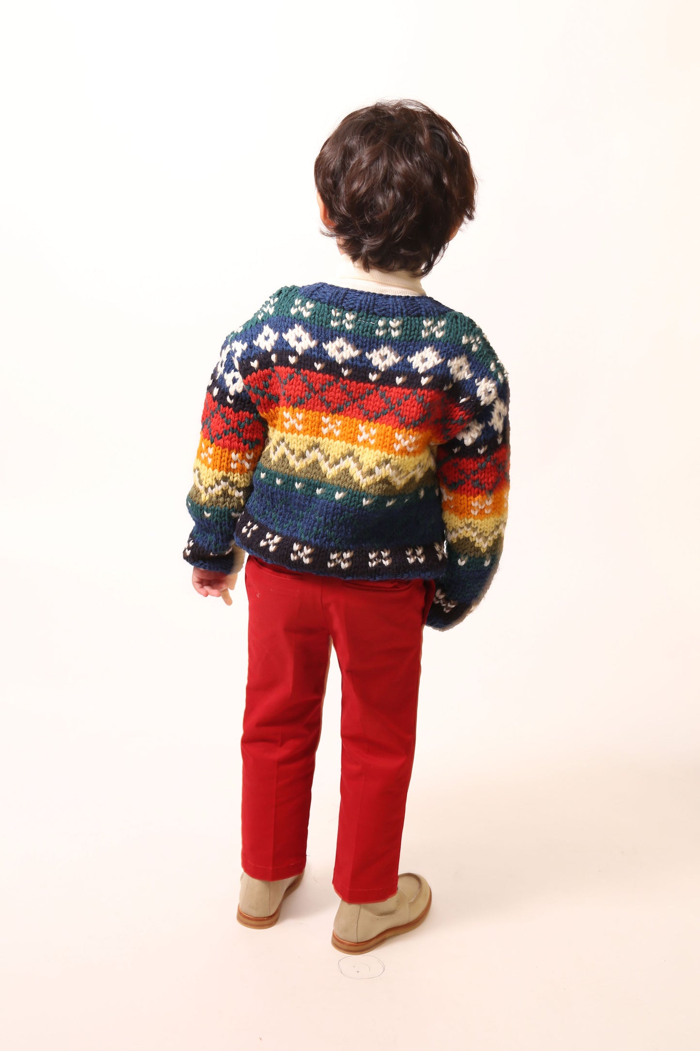 Boy a colorful knit sweater in multicolor Felt Wool Yarn, featuring a unique fair isle pattern. Designed with a classic crew neckline, relaxed fit, and dropped shoulders for all-day comfort and easy layering. Made from 100% Wool, ideal for winter wear. By Tia Cibani.