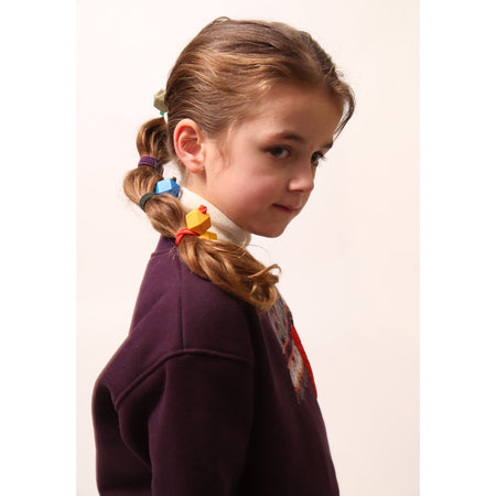 Girl wearing a set of 4 Tokyo ties with colorful wooden beads, perfect for buns, braids, pigtails, or ponytails,Tia Cibani.