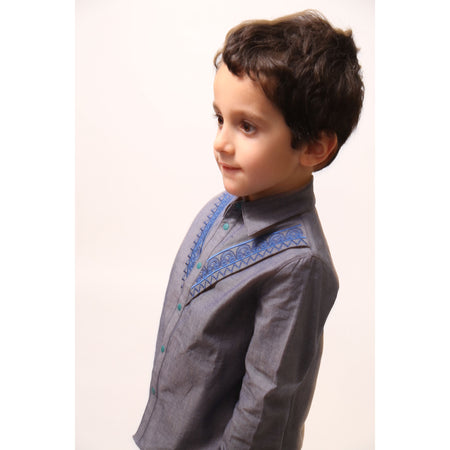 Boy wearing The Conan Embroidered Shirt, featuring high-low scoop hem and two-toned embroidered yoke. Collared with snap closure at center front. Perfect for casual and formal occasions. Colour: Blue,Tia Cibani.