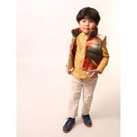 Boy wearing a sleeveless vest. Contrast color snaps at center front add pop of color and flair. Slanted pockets with pocket bag peering through at hem for style and warmth. Hint of taffeta at shoulders and back hemline for patchwork effect. Down-filled with high collar for warmth. Ideal for layering basic knits or thicker sweaters. Wool. Orange,Tia Cibani.