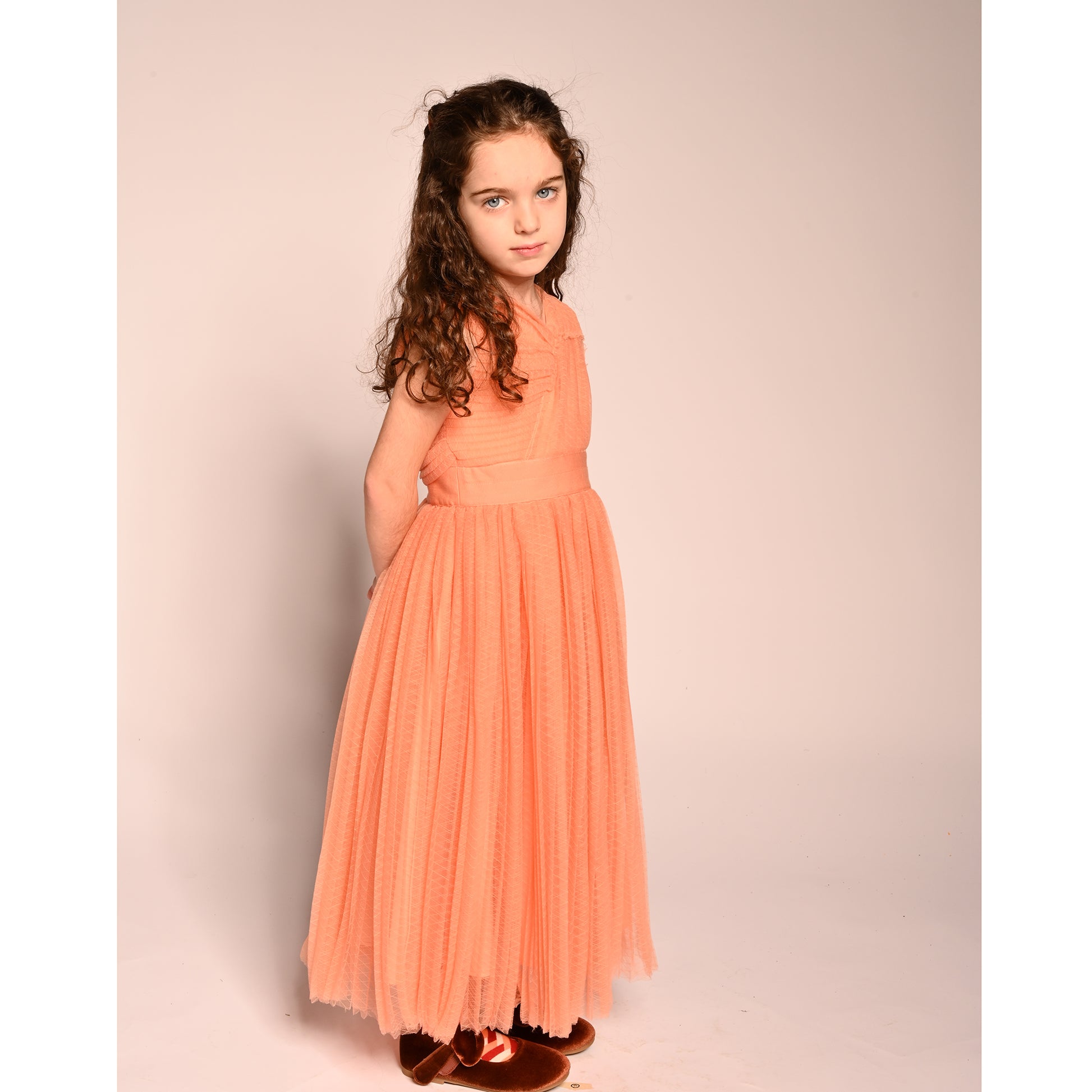 girl wearing orange pink tulle sleeveless gown length dress