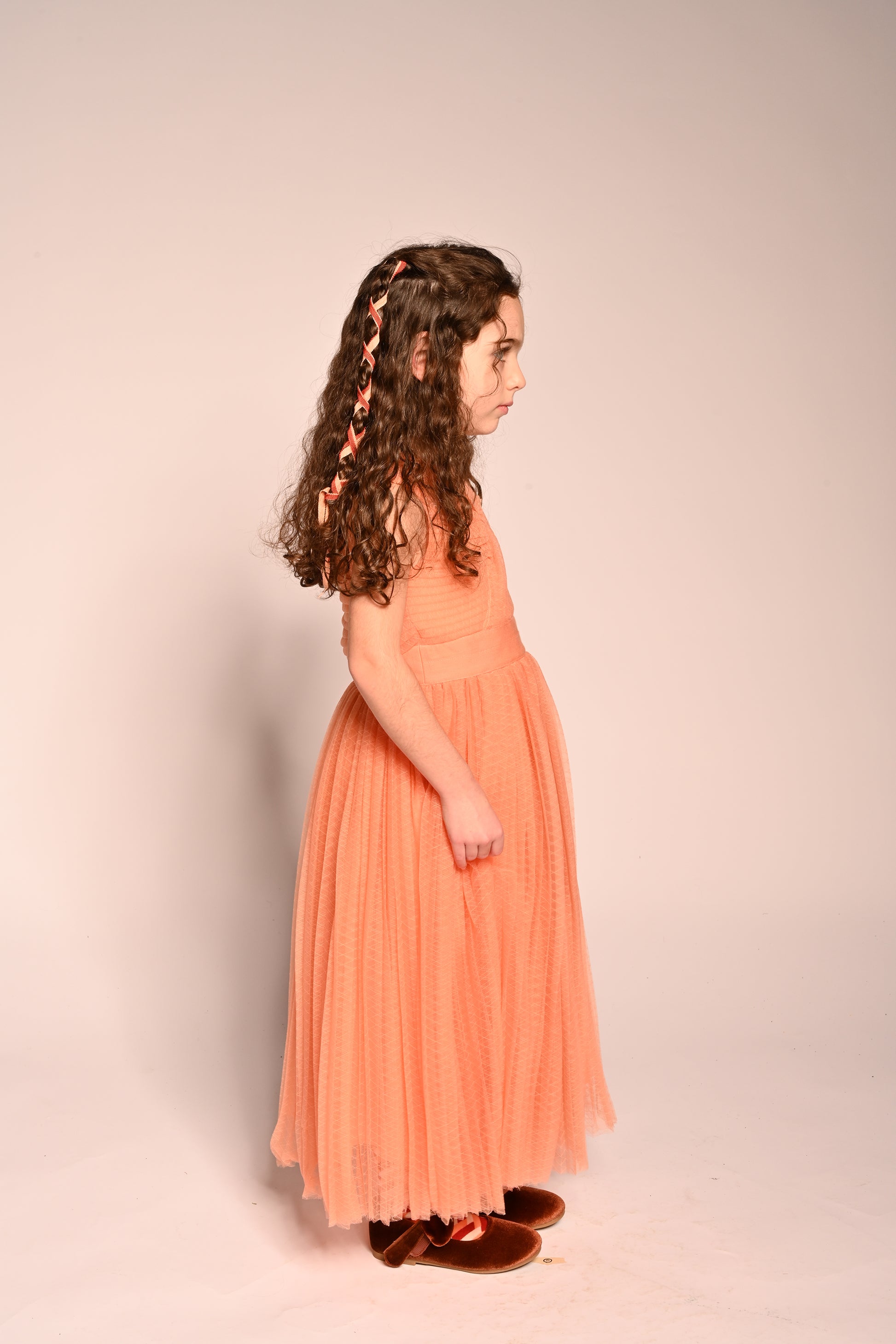 girl wearing orange pink tulle sleeveless gown length dress