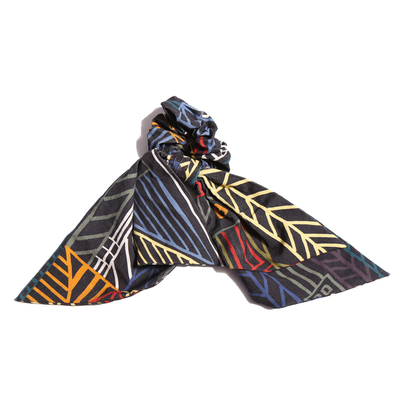 Scrunchie designed in Rainbow Normanz print, adorned with scarf-like tassels for a versatile look. Can be tied in a bow at the back or left free, by Tia Cibani.