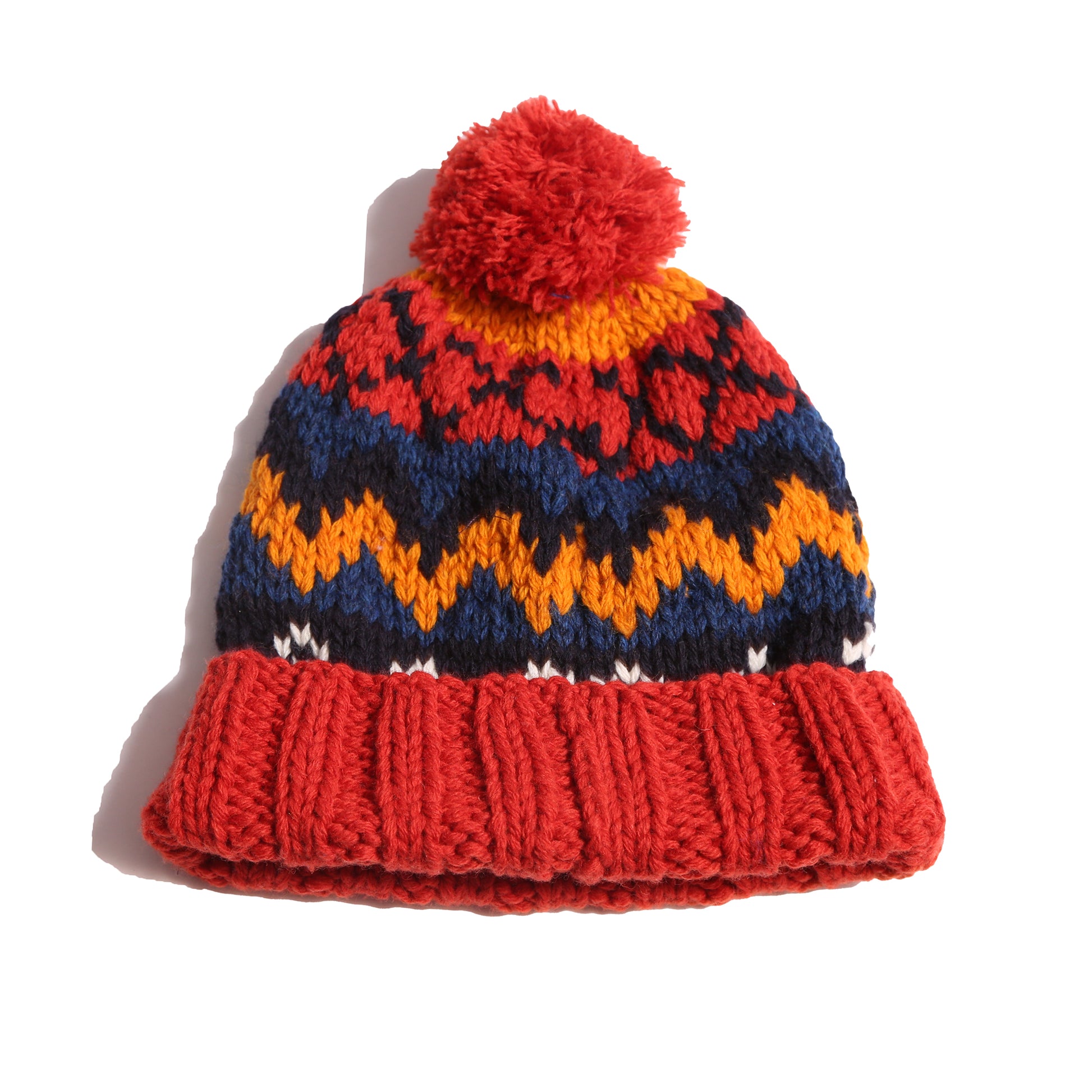 Hand-knitted toque in 100% wool with multi-colored fair isle pattern, large pom pom at top, and ribbing at bottom for easy folding. Colour: Blue and yellow, Tia Cibani.