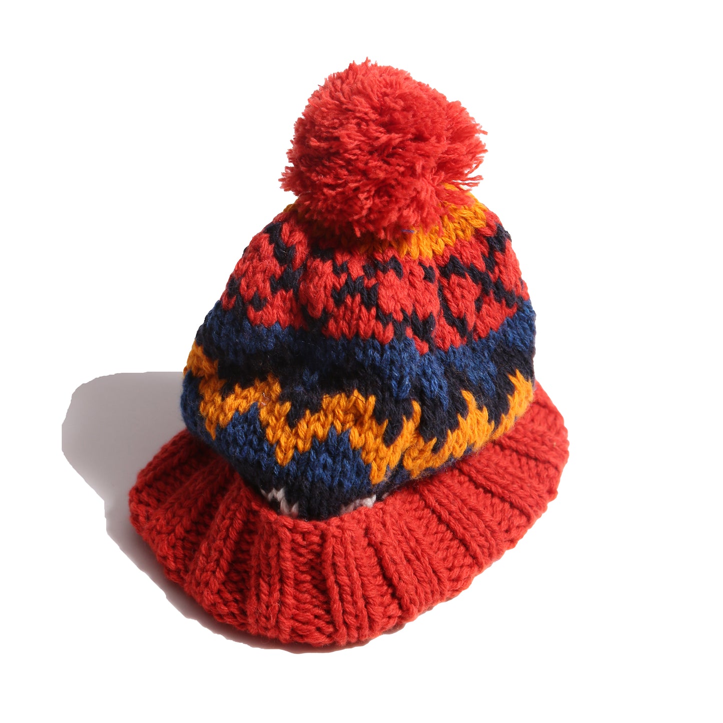 Hand-knitted toque in 100% wool with multi-colored fair isle pattern, large pom pom at top, and ribbing at bottom for easy folding. Colour: Blue and yellow, Tia Cibani.