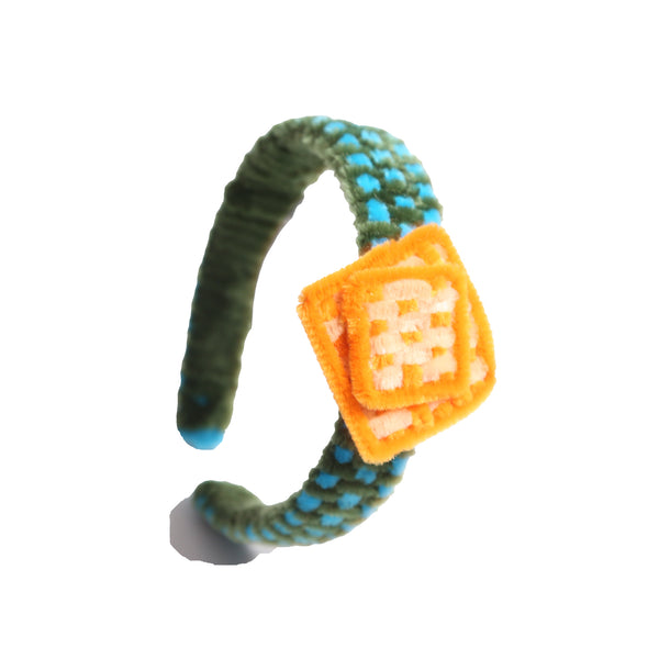 Headband wrapped and weaved in artistic two-tone effect using vibrant pipe cleaners. Topped with layers arranged asymmetrically in charming squares. Adds pop of color and personality to any hairstyle. Colours: Yellow, Sky Blue, Green,Tia Cibani.