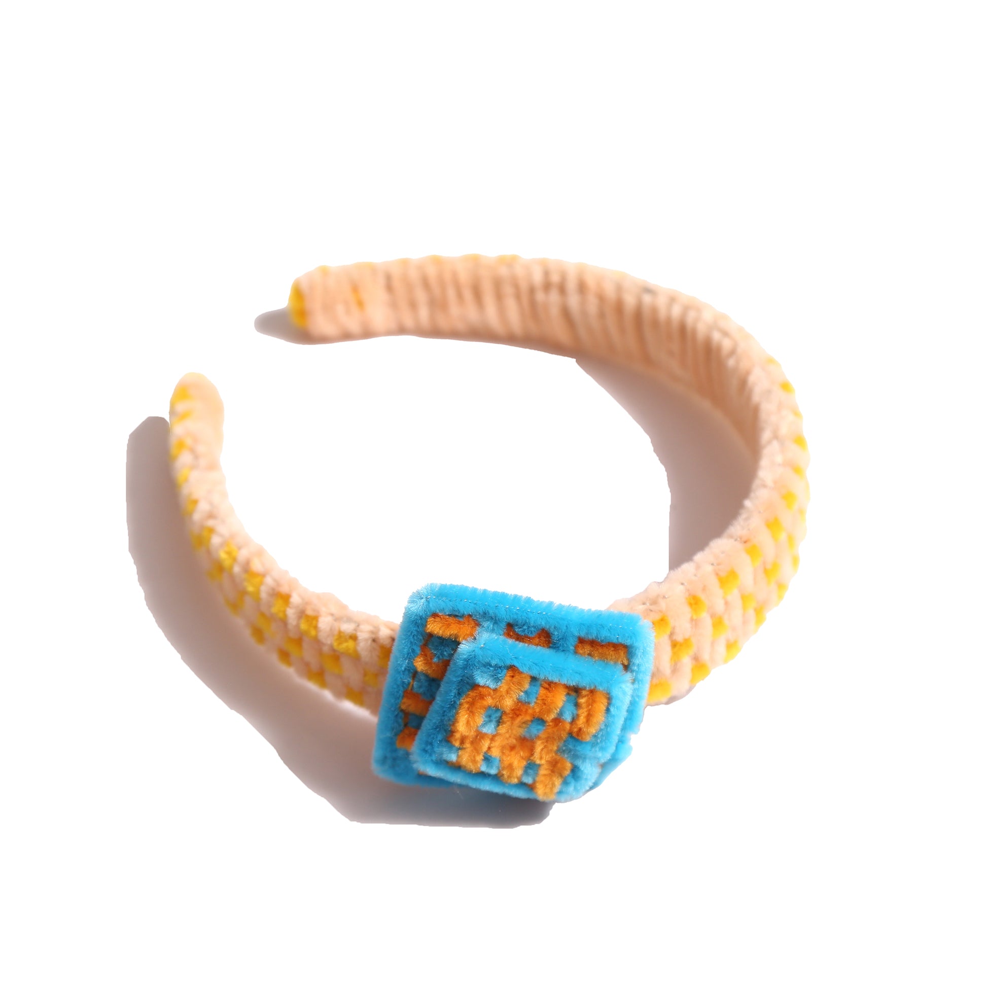 Headband wrapped and weaved in artistic two-tone effect using vibrant pipe cleaners. Topped with layers arranged asymmetrically in charming squares. Adds pop of color and personality to any hairstyle. Colours: Yellow, Sky Blue, Orange,Tia Cibani.