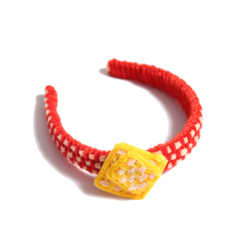 Headband wrapped and weaved in artistic two-tone effect using vibrant pipe cleaners. Topped with layers arranged asymmetrically in charming squares. Adds pop of color and personality to any hairstyle. Colours: Yellow, Red, Tia Cibani.