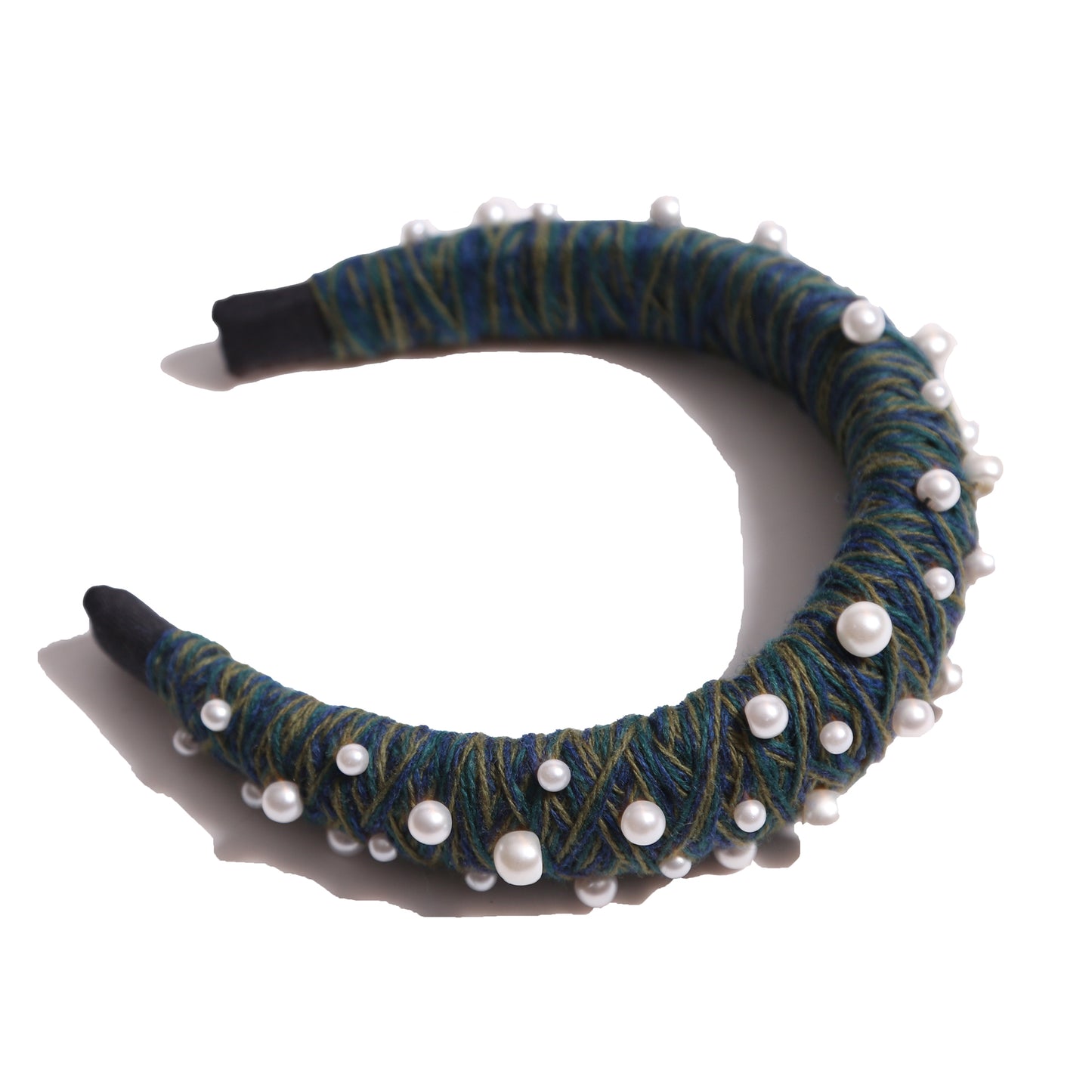 Headband covered in blue and green thread with various pearls attached, by Tia Cibani.