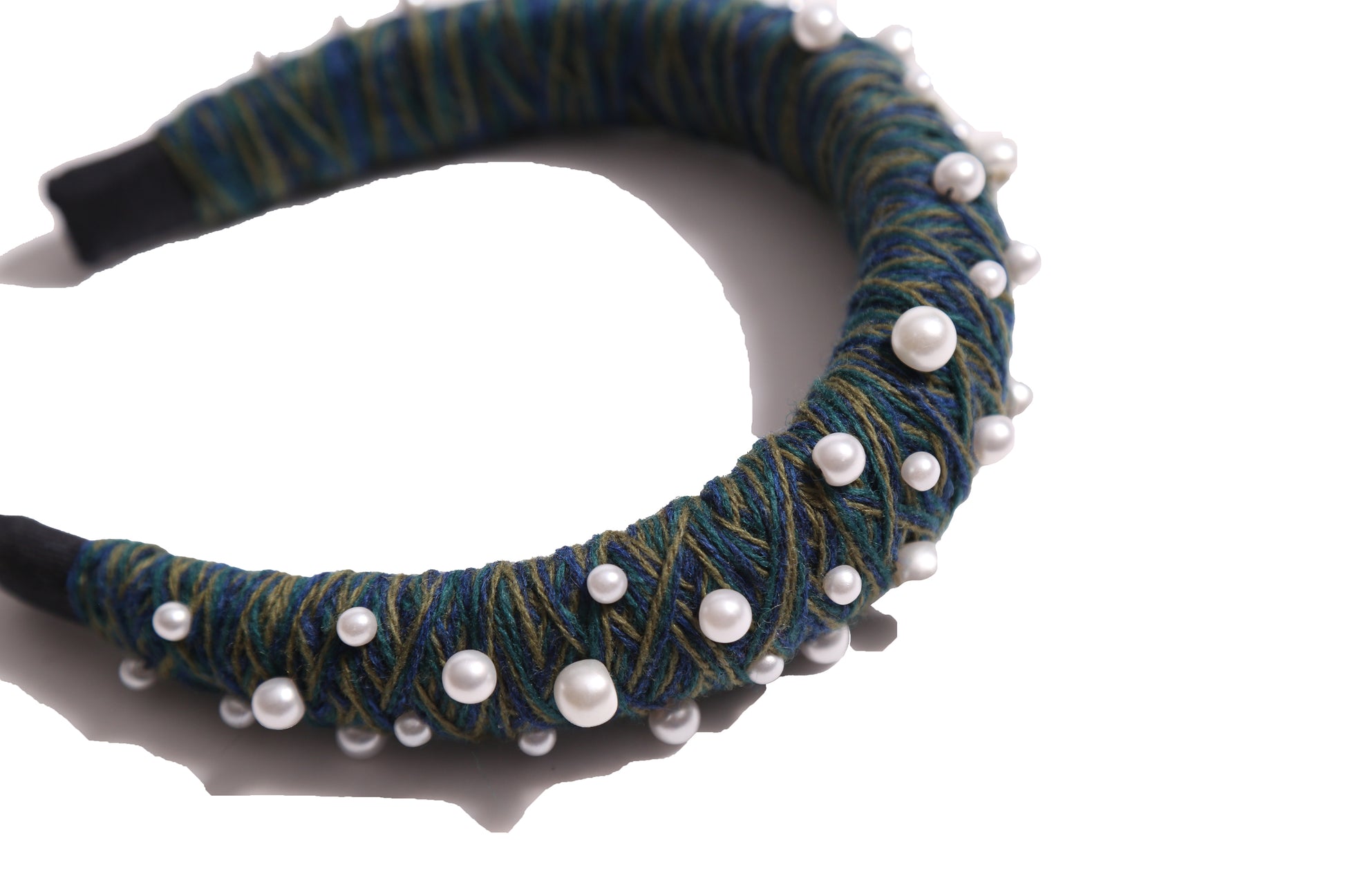 Headband covered in blue and green thread with various pearls attached, by Tia Cibani.