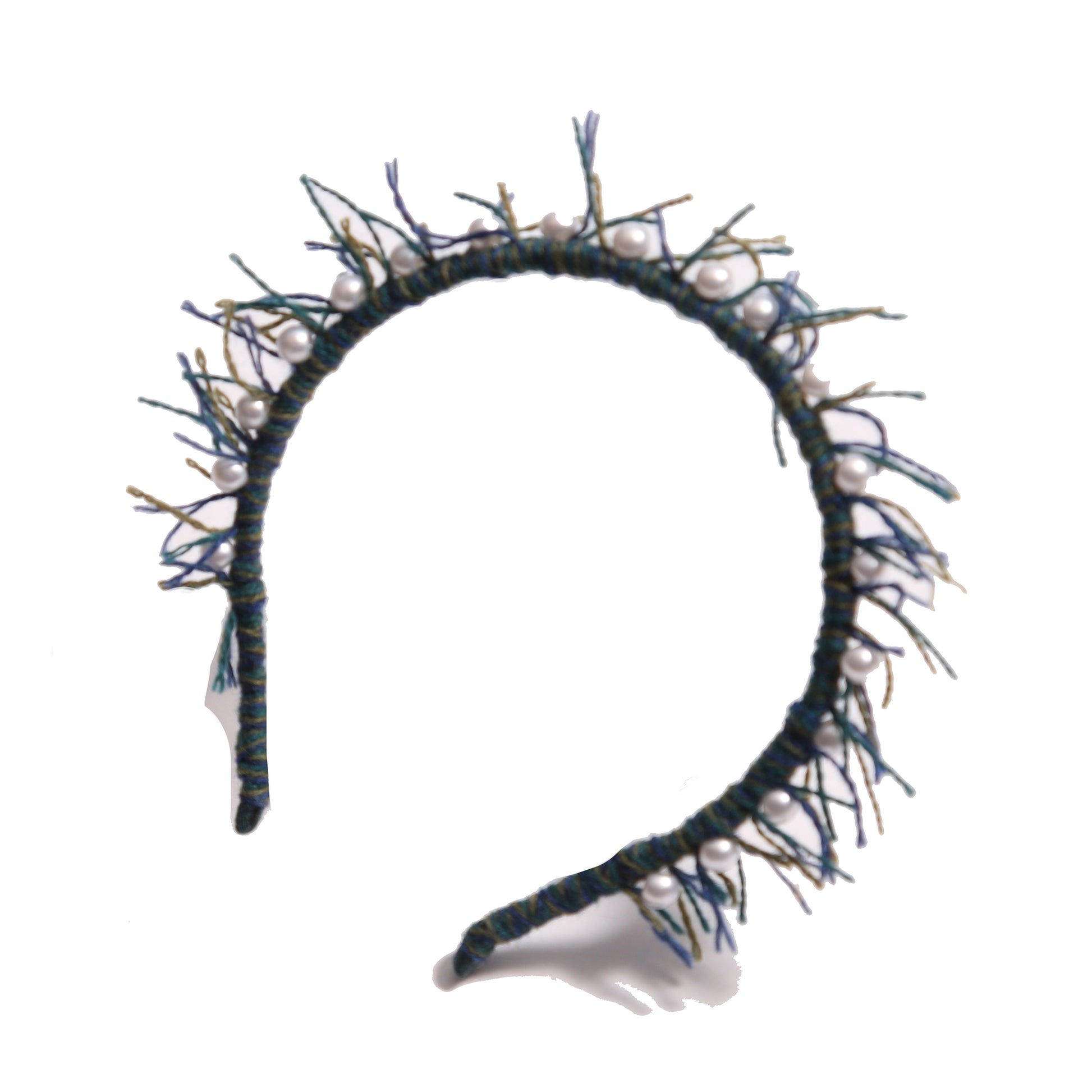 Headband wrapped in multi-colored, predominantly blue, wool yarn, with fringing at the crown and hand-stitched pearls at the top, by Tia Cibani.