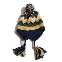 Cozy and playful toque style hat with multi-color tassels and pom pom at the top for a fun pop of color. Features ear flaps for extra warmth, hand-knitted with charming colorful fair isle pattern. Made of 100% Wool. Wear with this season's fair isle sweaters or outerwear pieces. Blue and yellow, Tia Cibani.