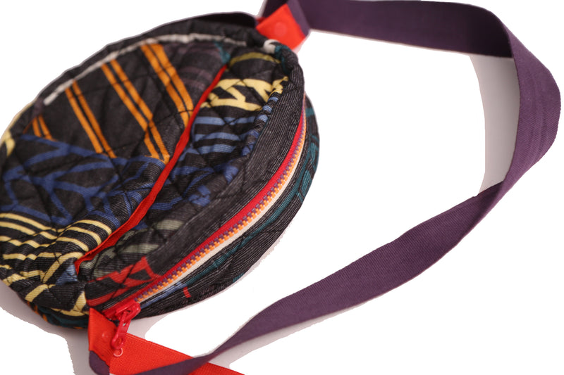 Timeless bum bag in Normanz print, featuring diamond harlequin tufting pattern. Multi-colored zipper, pockets with snaps, cotton canvas ribbon strap. Additional snap-tape strap for crossbody or waist wear as fanny pack. Rainbow, Tia Cibani.