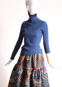 Slim fit, ribbed Felted Wool Yarn turtleneck with multi-color contrasting patchwork at sleeves. Bold spin on classic basic for mom. High-quality knit staple for fall and winter seasons. Wool, Blue. By Tia Cibani.