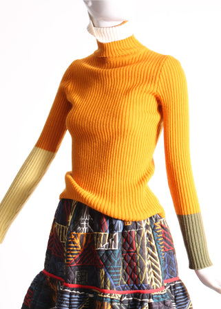 Slim fit, ribbed Felted Wool Yarn turtleneck with multi-color contrasting patchwork at sleeves. Bold spin on classic basic for mom. High-quality knit staple for fall and winter seasons. Wool, pepon. By Tia Cibani.