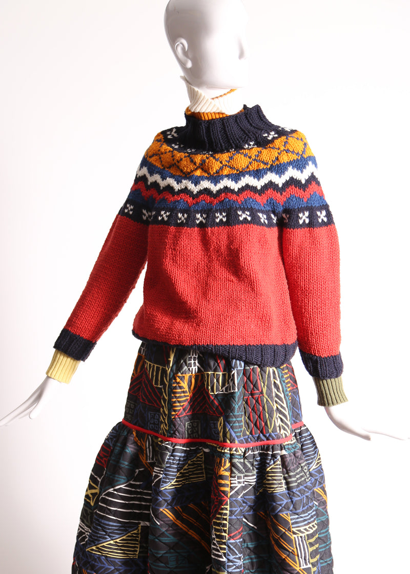 Fair isle knit sweater for mom, featuring mock neckline, ribbing at neckline, sleeve cuffs, and hem for snug fit. Crafted in cozy wool for warmth and style. Dropped armholes, raglan sleeves for relaxed silhouette. Ornate, colorful fair isle patterned collar adds charm. Perfect for lounging or exploring outdoors. Match with Aela Fair Isle Sweater for mini. Wool. Red, Tia Cibani.