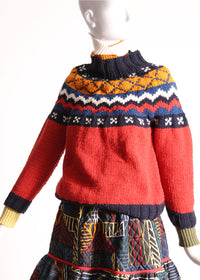 Fair isle knit sweater for mom, featuring mock neckline, ribbing at neckline, sleeve cuffs, and hem for snug fit. Crafted in cozy wool for warmth and style. Dropped armholes, raglan sleeves for relaxed silhouette. Ornate, colorful fair isle patterned collar adds charm. Perfect for lounging or exploring outdoors. Match with Aela Fair Isle Sweater for mini. Wool. Red, Tia Cibani.