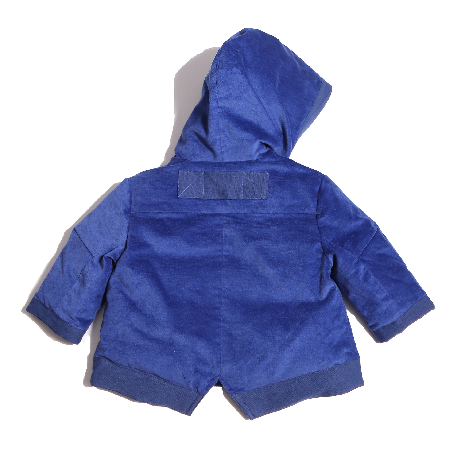 Baby coat made from Blue Breton Tarp Velvet, featuring down filling, an attached hood, slanted ribbon welt pockets, a V cut-out vent at the back hemline, and a center front zipper with a multi-colored ribbon pully for added flair. Lined with soft jersey at the body and nylon lining in the sleeves, by Tia Cibani.