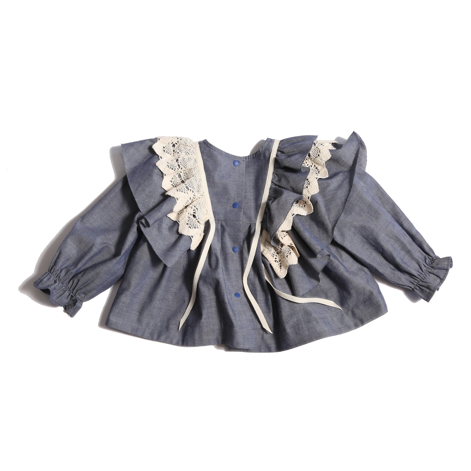 Baby blouse in 100% Cotton with 3-dimensional lace trim ruffling at shoulders, self-ruffles, and decorative ribbon. Snaps at back, cinched long sleeves for snug fit. Unlined for lightweight feel. Colour: Blue, Tia Cibani.