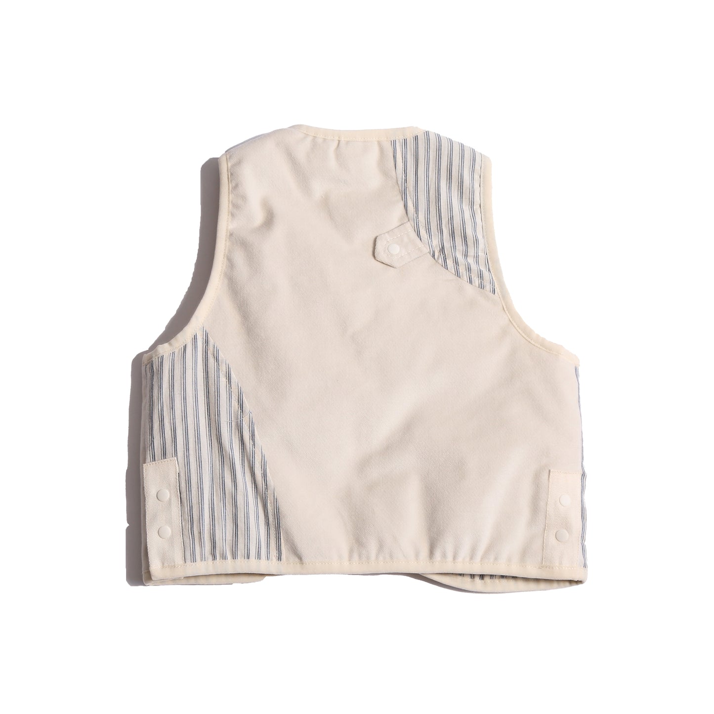  Padded patchwork vest in White, featuring an easy box fit for layering and comfort. Includes binding tape at all edges, patch pockets for storage, and a snap button closure at the center front flap. Made from structured velvet and soft cotton striped shirting, fully faced for added comfort. Versatile and stylish, perfect for any occasion, by Tia Cibani.