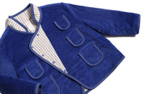 Padded patchwork jacket for boys with easy relaxed fit for comfort and layering. Double snap placket closure adds military-inspired flair. Fully faced with soft cotton striped shirting and patchworked with structured velvet on the outside. Features multiple patch pockets for treasures, binding tape trim throughout, and stand-up collar. Pair with Breton Slim Fit Trousers for refined look. Blue and white, Tia Cibani.