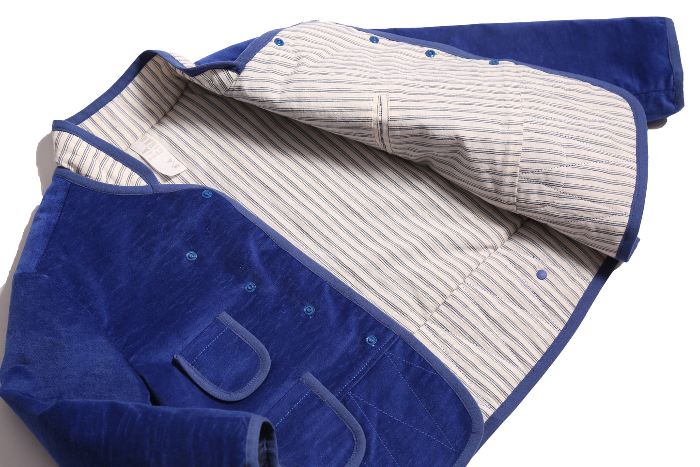 Padded patchwork jacket for boys with easy relaxed fit for comfort and layering. Double snap placket closure adds military-inspired flair. Fully faced with soft cotton striped shirting and patchworked with structured velvet on the outside. Features multiple patch pockets for treasures, binding tape trim throughout, and stand-up collar. Pair with Breton Slim Fit Trousers for refined look. Blue and white, Tia Cibani.