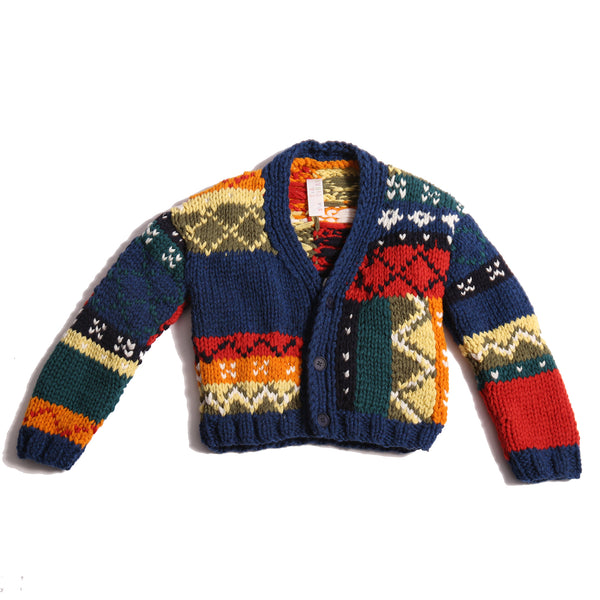  Colorful fair isle cardigan in a patchwork design, blending various fair isle patterns with solid colors of Felt Wool Yarn. Features a relaxed fit with faux horn buttons at the center front, ideal for layering over basic knits. Made from 100% Wool. Color: Multicolor. By Tia Cibani.