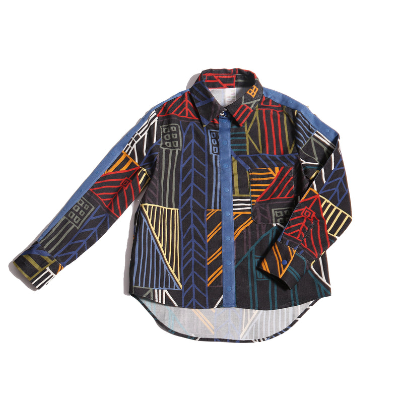 Collared shirt in Rainbow Normanz print, featuring colorful trims and blue snap tape detailing down the arms and at center front for button enclosure. Made from 100% Cotton, versatile for both casual and dressy settings, by Tia Cibani.