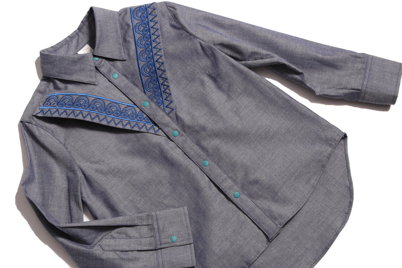 The Conan Embroidered Shirt, featuring high-low scoop hem and two-toned embroidered yoke. Collared with snap closure at center front. Perfect for casual and formal occasions. Colour: Blue,Tia Cibani.