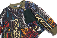 Diamond harlequin tufted top in Normanz print, patchworked with Liquid Canvas at chest pocket for contrast. Snap buttons at shoulder, ribbing at collar and cuffs, side seam zipper vents. Scoop hem pullover, padded throughout for warmth, fully lined in soft jersey. Ideal for chilly fall/winter days, pairs perfectly with Harlequin Padded Track Pants for complete rainbow ensemble. Dark Rainbow, Tia Cibani.