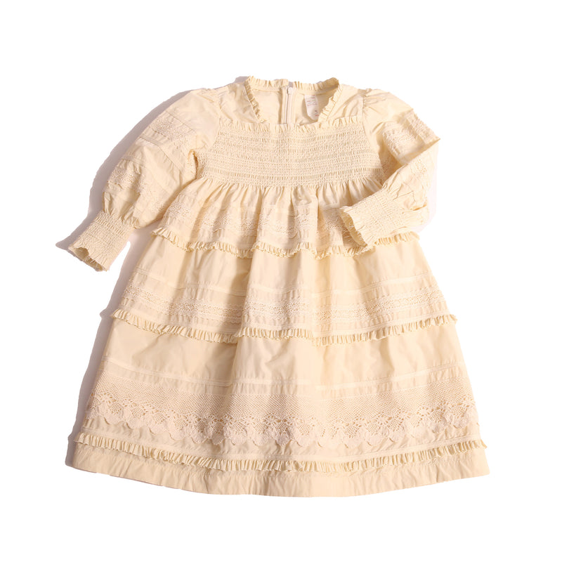 Tealength frock in luxurious Taffeta with elasticized smocking at bust and cuffs, tiers of ribbons and lace trim, invisible zipper at back, long cinched sleeves, and square ruffled neckline. Unlined for lightweight feel. Colour: White, Tia Cibani.