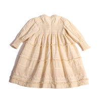 Tealength frock in luxurious Taffeta with elasticized smocking at bust and cuffs, tiers of ribbons and lace trim, invisible zipper at back, long cinched sleeves, and square ruffled neckline. Unlined for lightweight feel. Colour: White, Tia Cibani.