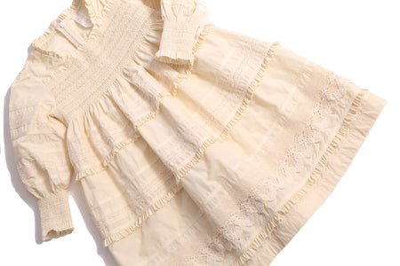 Tealength frock in luxurious Taffeta with elasticized smocking at bust and cuffs, tiers of ribbons and lace trim, invisible zipper at back, long cinched sleeves, and square ruffled neckline. Unlined for lightweight feel. Colour: White, Tia Cibani.
