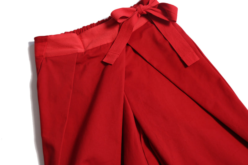 Deep pleated trousers designed for comfort and style, featuring an easy elastic waistband with ribbon tie detailing for a charming bow at the side waist. Crafted in comfortable Chamois Cotton Twill, unlined for lightweight feel, perfect for everyday wear. Complete with slant pockets at side seams. Pair with Gwenn Collared Topper for a complete look. Rouge, Tia Cibani.