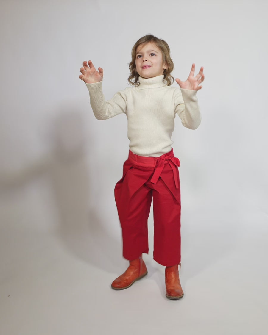 Girl wearing a charming volume topper jacket in soft Chamois Cotton Twill with contrasting lace embellishments, Red and White, Tia Cibani.